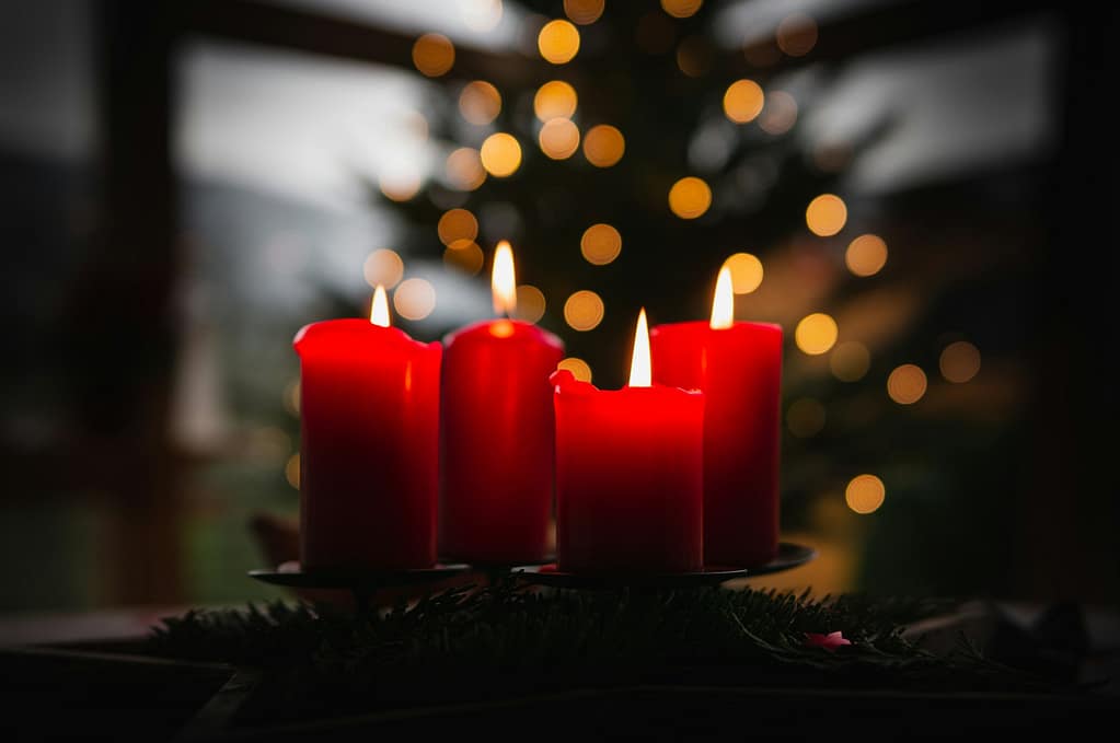 Adventskranz mit vier brennenden roten Kerzen