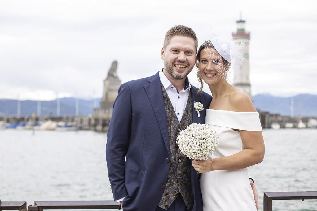 Brautpaar am Lindauer Hafen mit Leuchtturm im Hintergrund, Schleierkraut-Strauß