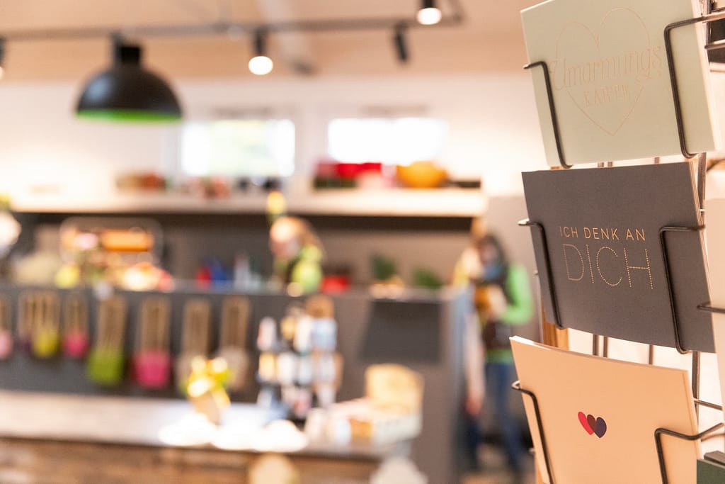 Grußkarten-Ständer mit Karten wie "Ich denk an dich" im Blumenladen Heck
