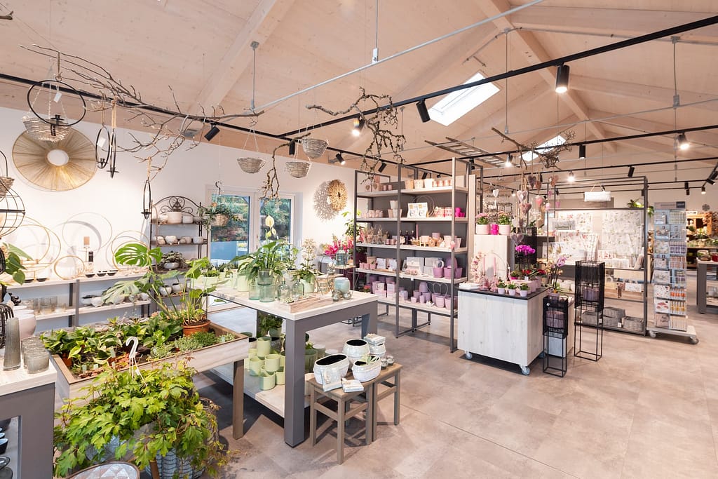 Verkaufsraum im Blumenladen Heck mit Deko-Laternen, Wandornament und frischen Grünpflanzen