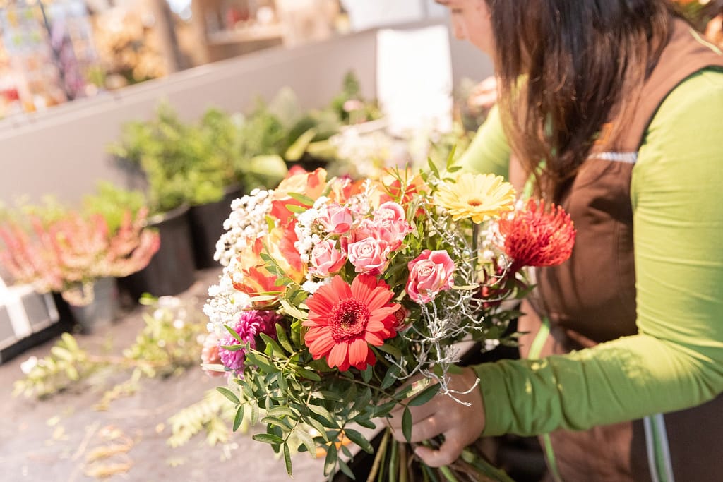 Floristin von Blumen Heck bindet einen bunten Strauß im Laden in Tettnang
