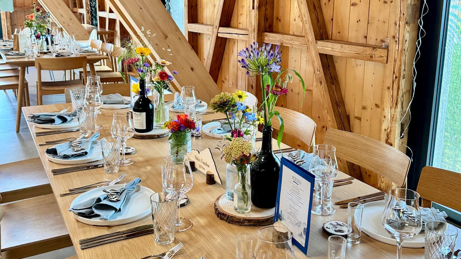 Festlich gedeckte Hochzeitstafel im Hopfengut No. 20 in Tettnang mit bunten Wildblumen-Gestecken
