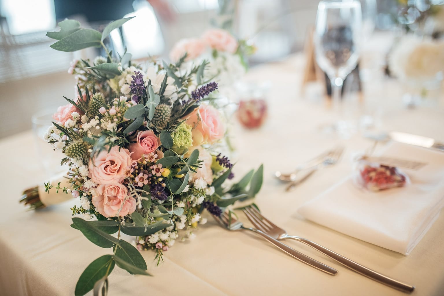 Brautstrauß in Rosé und Lavendel auf einer gedeckten Hochzeitstafel