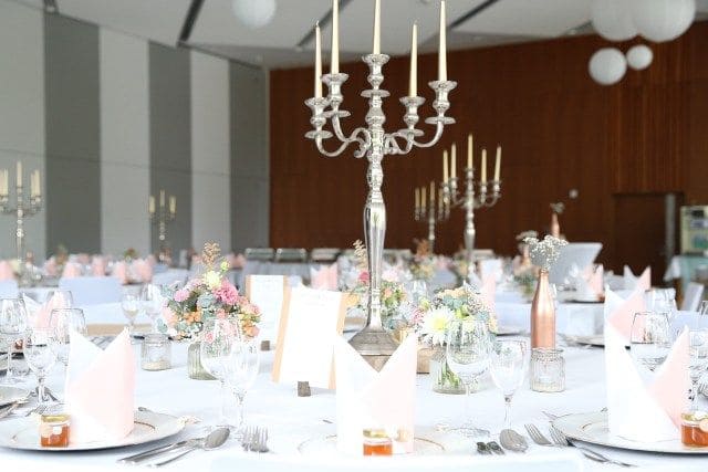 Elegant gedeckter Tisch mit Silberkerzenständer und rosa Servietten