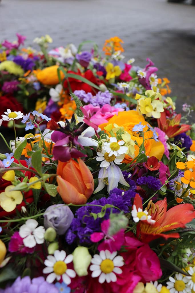 Bunte Sargauflage mit oranger Ranunkel und Tulpe, Nahaufnahme