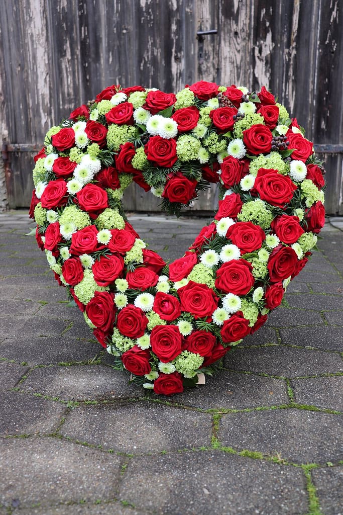 Rotes Herzgesteck aus Rosen mit weißen Chrysanthemen