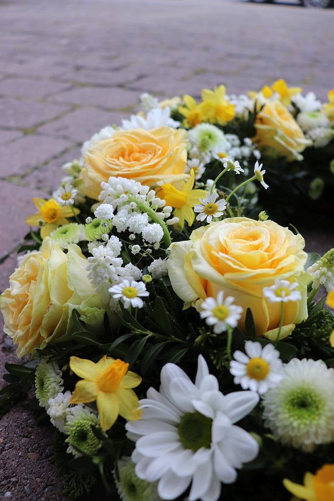 Gelbe Sargauflage mit Rosen und Narzissen, Nahaufnahme