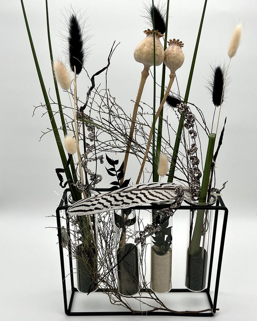 Trockenblumen-Gesteck mit Gräsern und Mohnkapseln in Glasröhrchen