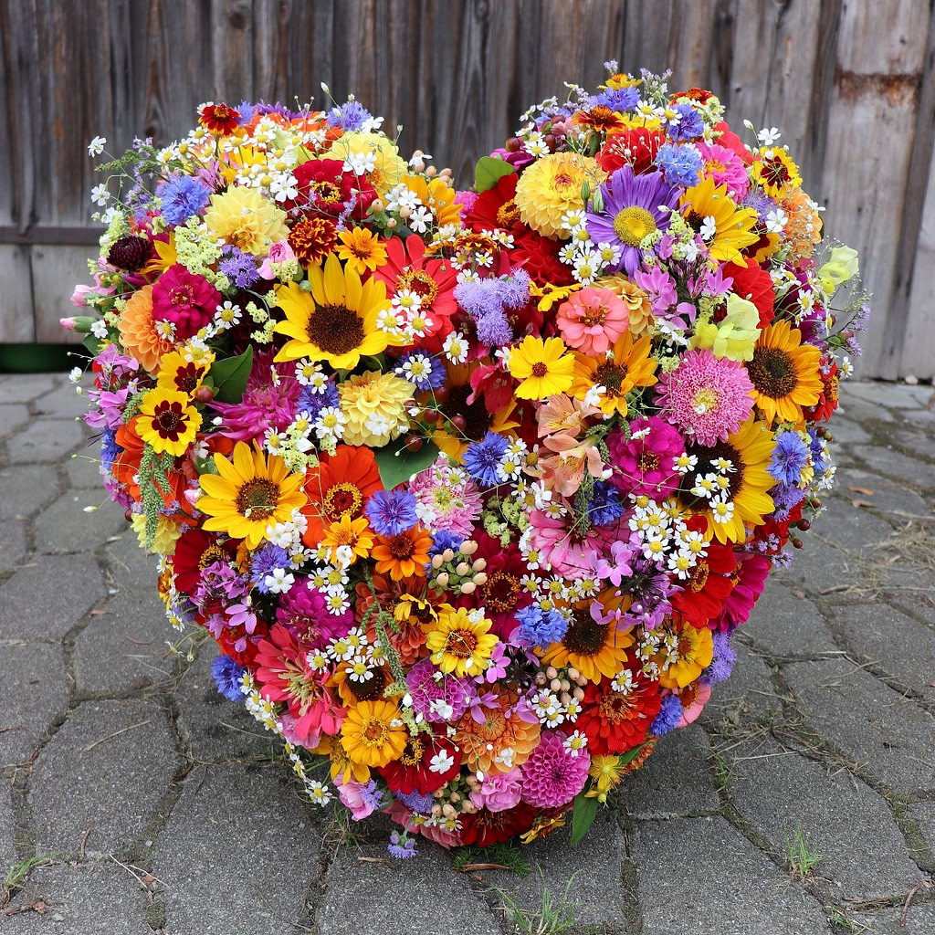 Trauerherz aus Sonnenblumen, Zinnien und Dahlien