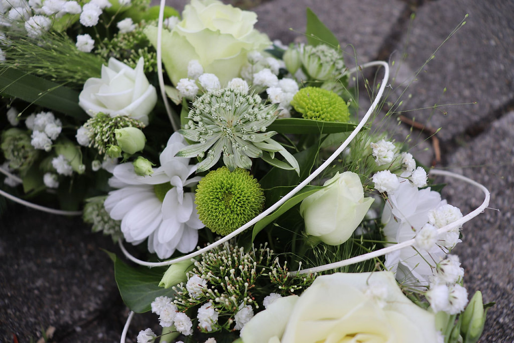 Weiß-grünes Trauergesteck mit Rosen