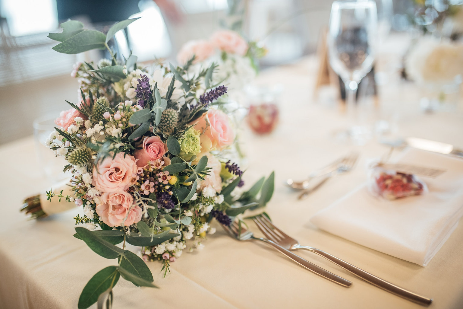 Brautstrauß in Rosé und Lavendel auf einer gedeckten Hochzeitstafel